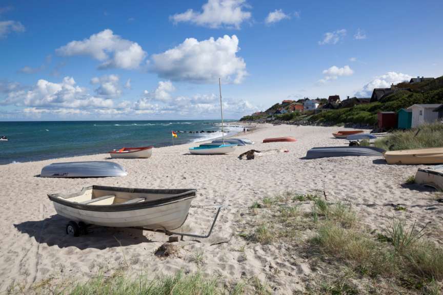 Eine Gruppe von Booten liegt auf einem sandigen Strand