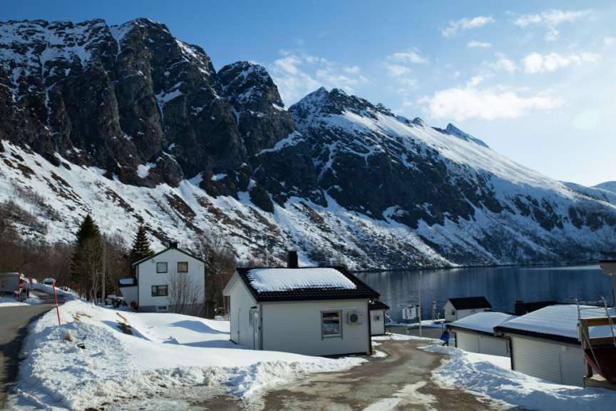 Ein kleines weißes Haus steht inmitten einer schneebedeckten Landschaft