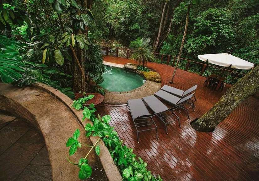 Ein Holzdeck mit einem Pool und Liegestühlen darauf