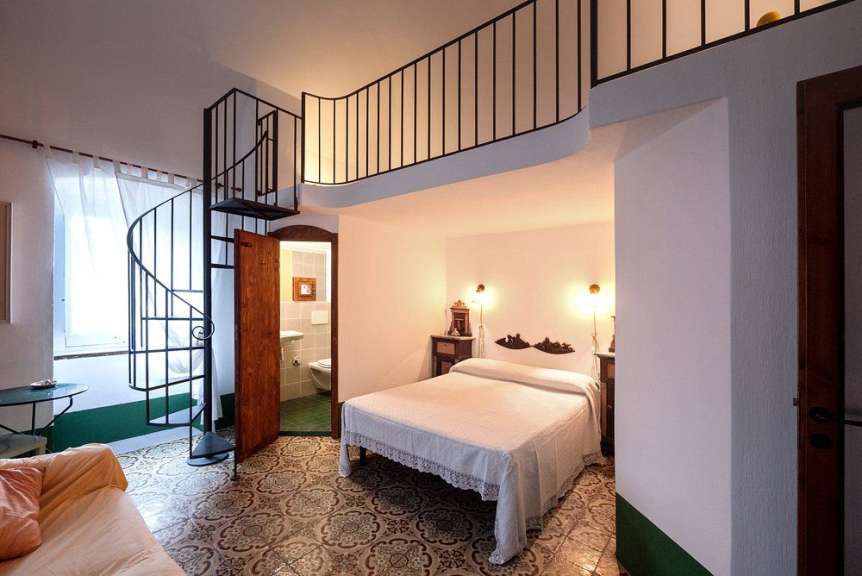 Ein Schlafzimmer mit einem Bett und einer spiralförmigen Treppe
