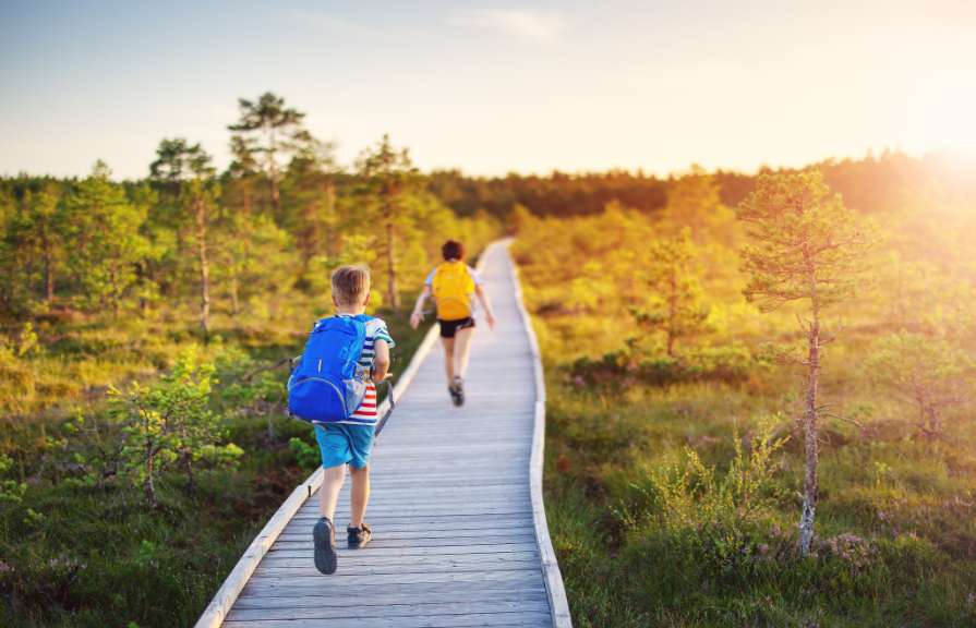 Eine Frau und ein Junge gehen auf einem Holzsteg