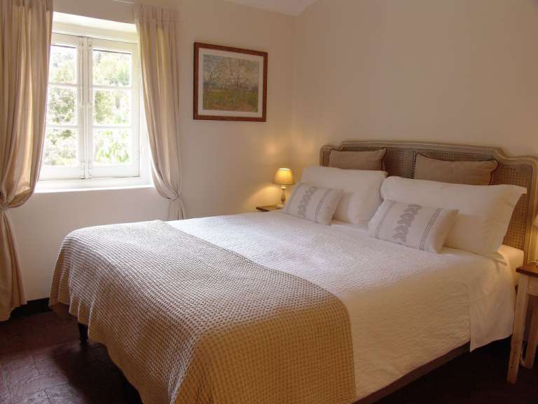 Ein Schlafzimmer mit einem Bett und einem Gemälde an der Wand