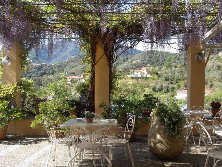 Ein Tisch und Stühle auf einer Terrasse mit Blick auf die Berge