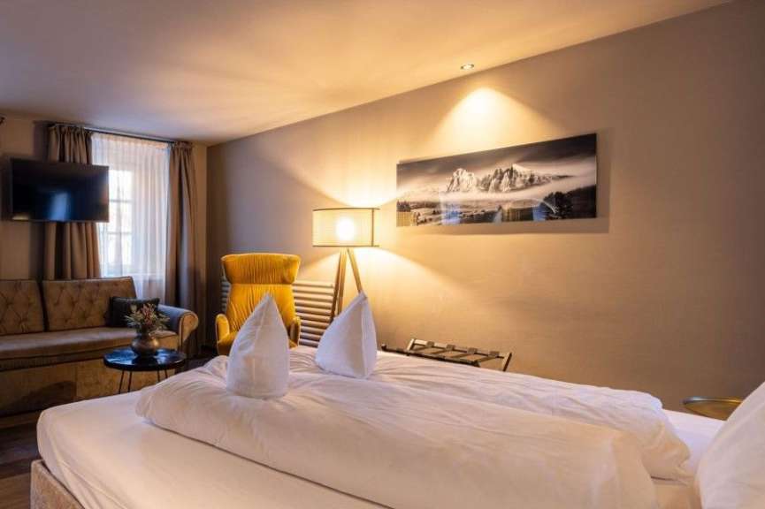 Ein Hotelzimmer mit einem Bett und einem Gemälde an der Wand