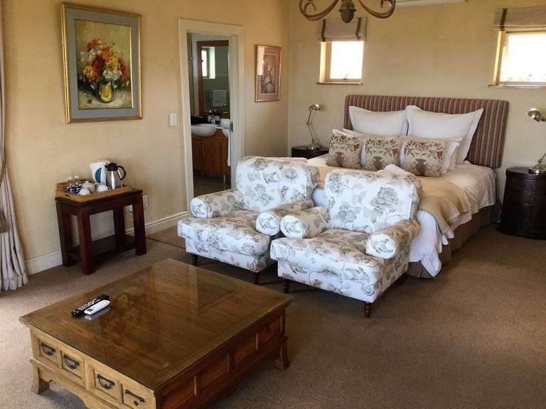 Ein Schlafzimmer mit zwei Stühlen und einem Tisch