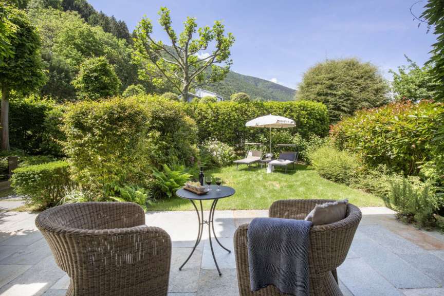 Zwei Stühle sitzen auf einer Terrasse mit einem Tisch und einem Sonnenschirm
