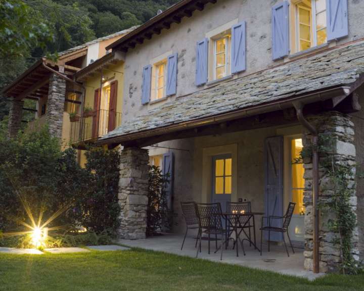 Ein Haus mit blauen Fensterläden und einem Tisch und Stühlen