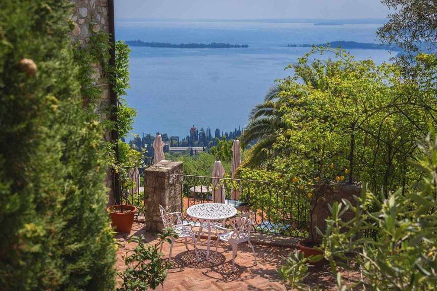 Ein Tisch und Stühle auf einem Balkon mit Blick auf einen See