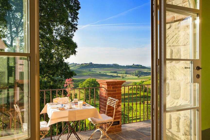 Ein Tisch und Stühle auf einem Balkon mit Blick auf die Landschaft