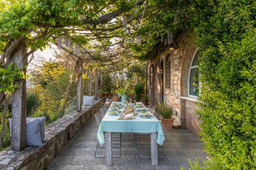 Ein Tisch mit einem blauen Tischtuch auf einer Terrasse