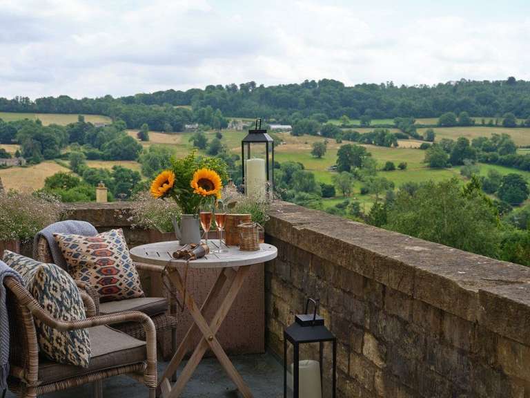 Auf einem balkon steht ein tisch mit blumen und kerzen