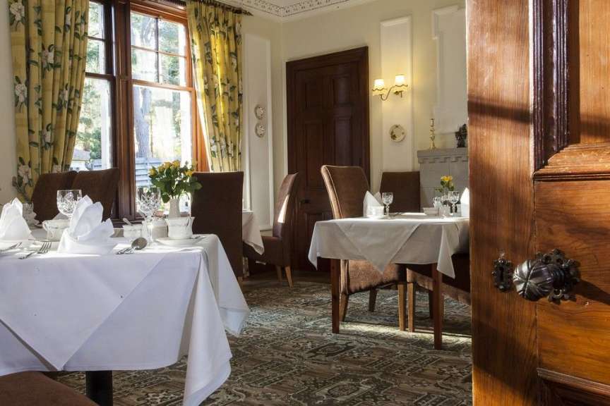 Ein Esszimmer mit Tischen und Stühlen mit weißen Tischdecken