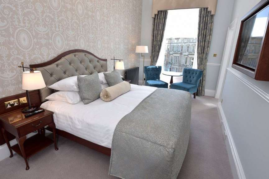 Ein Hotelzimmer mit einem Bett und zwei Stühlen