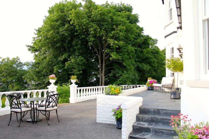 Eine Terrasse mit einem Tisch und Stühlen vor einem weißen Gebäude