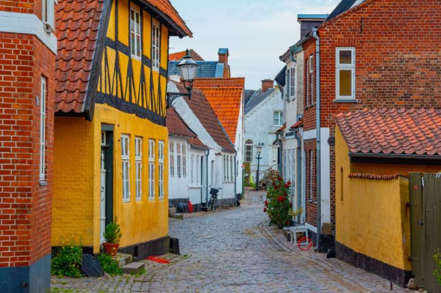 Eine Straße mit gelben Gebäuden und roten Backsteinhäusern