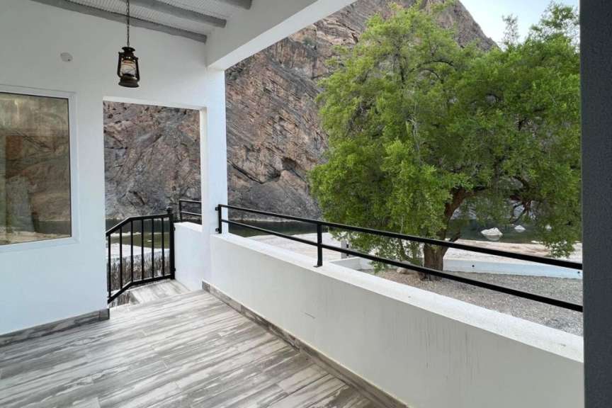 Ein Balkon mit Blick auf einen Fluss und einen Baum