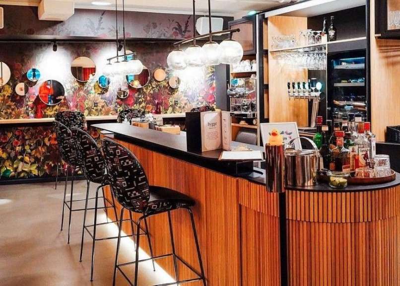 Eine Bar mit Stühlen und Flaschen an der Theke