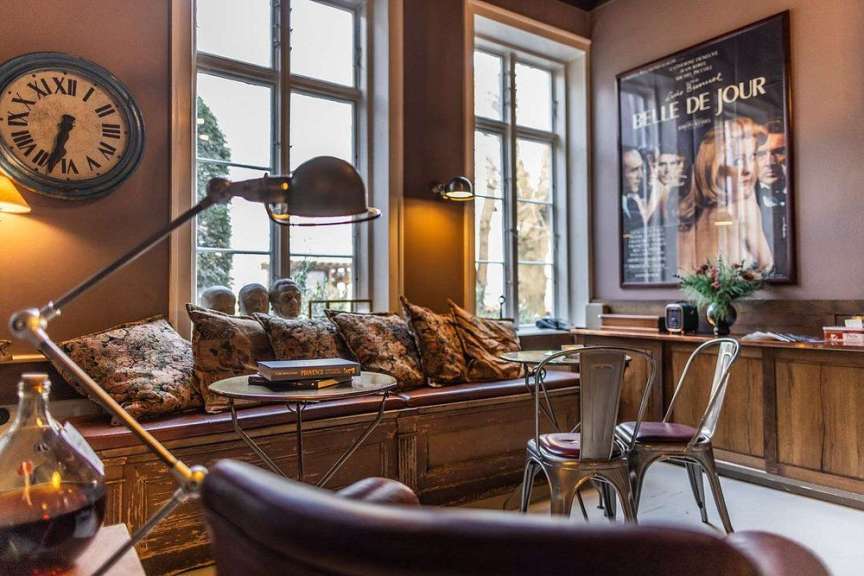 Ein Wohnzimmer mit einer Uhr und einem Poster für belle de jour