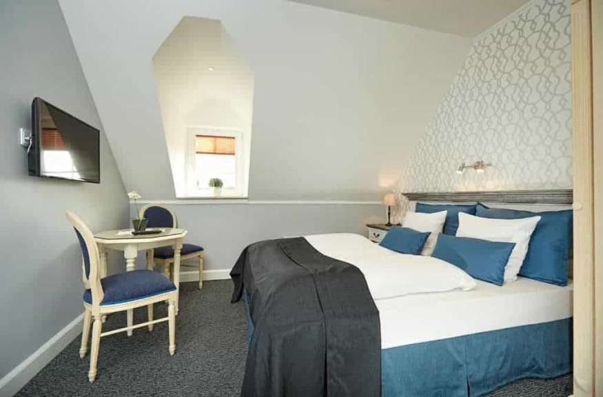 Ein Hotelzimmer mit einem Bett, einem Tisch und einem Fernseher