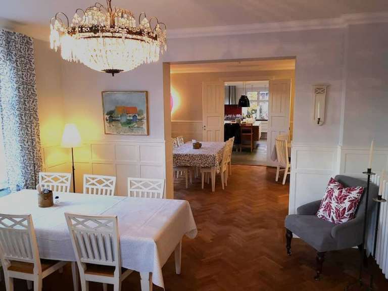 Ein Esszimmer mit einem Tisch und Stühlen und einem Kronleuchter