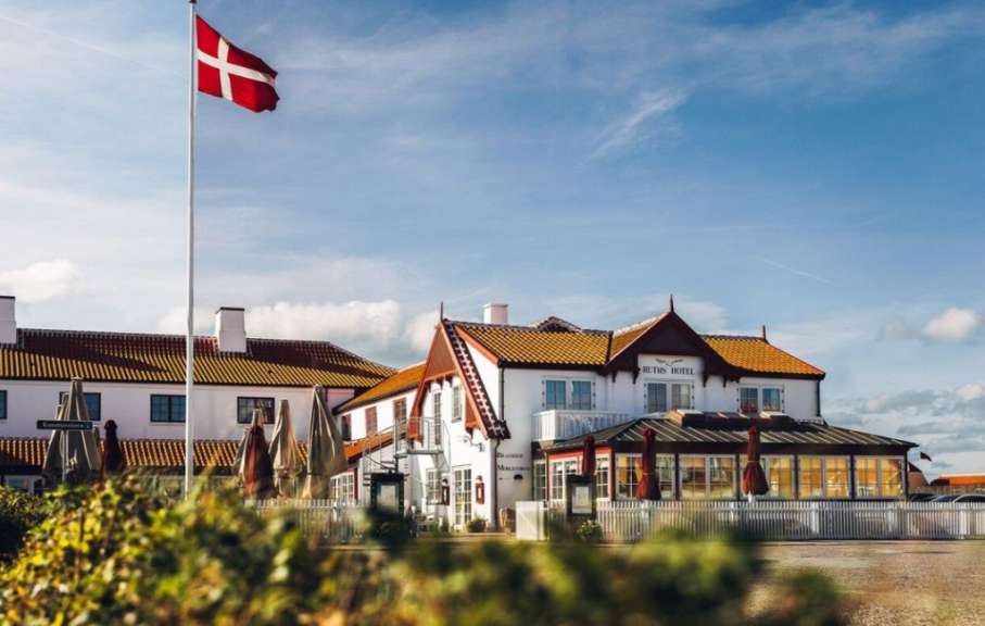 Eine dänische Flagge weht vor einem weißen Hotel