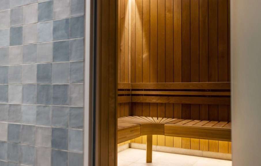 Eine Holzsauna mit blauen Fliesen an der Wand