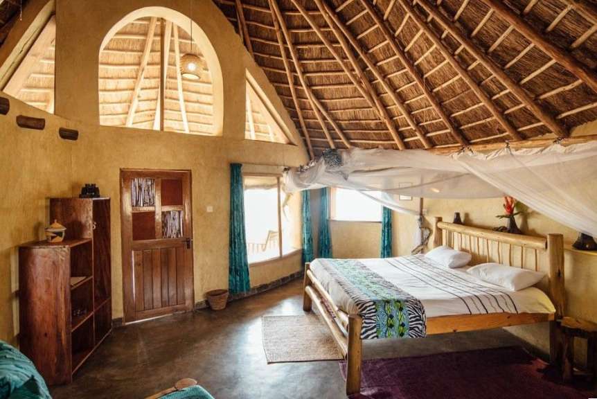 Ein Zimmer mit einem Bett und einem Strohdach