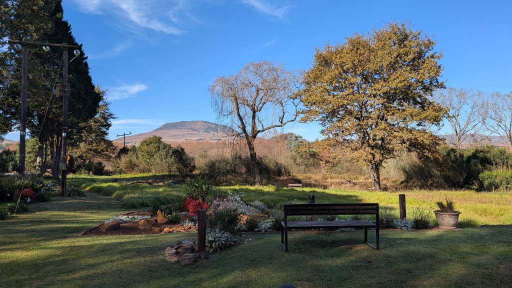 Eine Bank in einem Garten mit einem Berg im Hintergrund