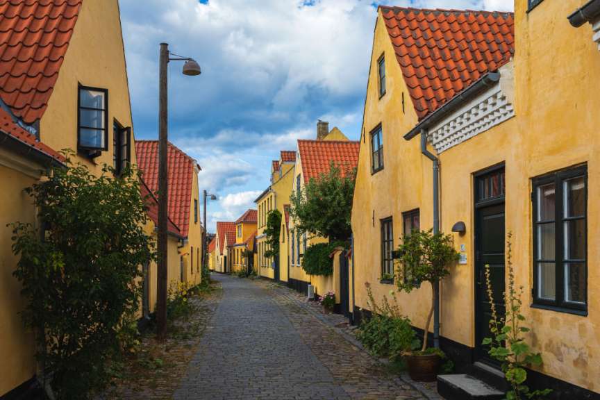 Eine Straße mit gelben Häusern und roten Dächern