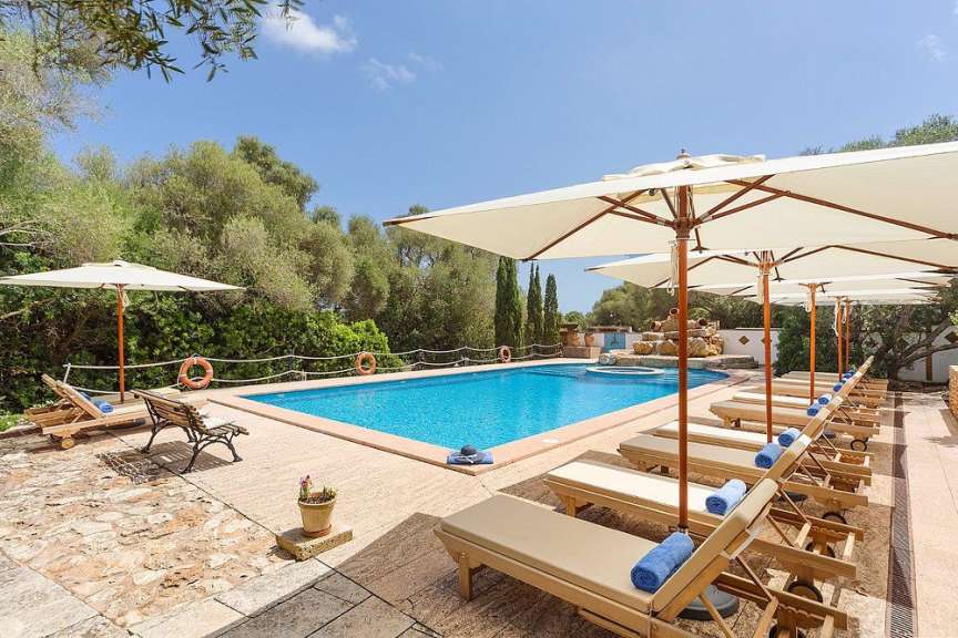 Liegestühle und Sonnenschirme um einen großen Swimmingpool