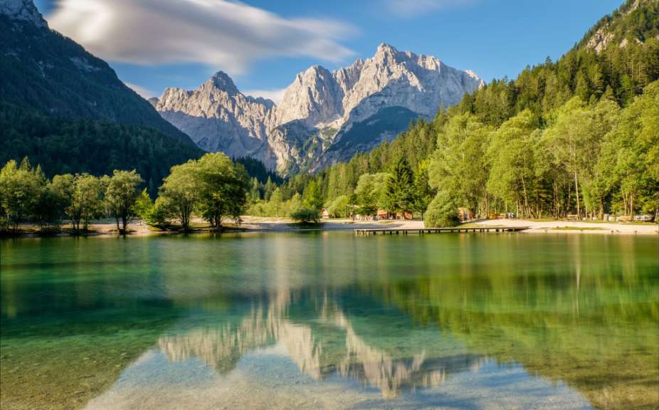 Ein See mit Bäumen und Bergen im Hintergrund
