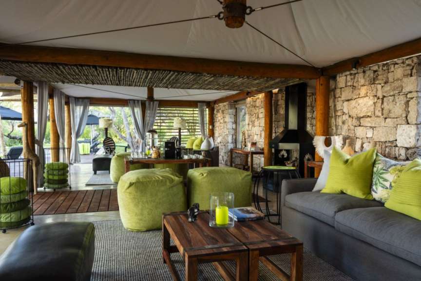 Ein Wohnzimmer mit einem grauen Couch und grünen Kissen