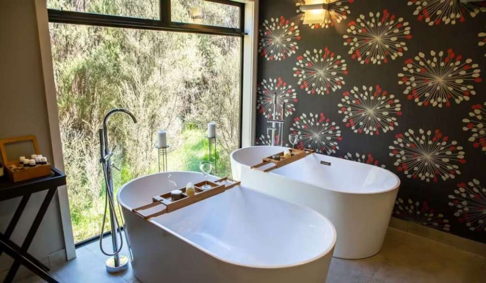 Ein Badezimmer mit zwei Badewannen und einem großen Fenster