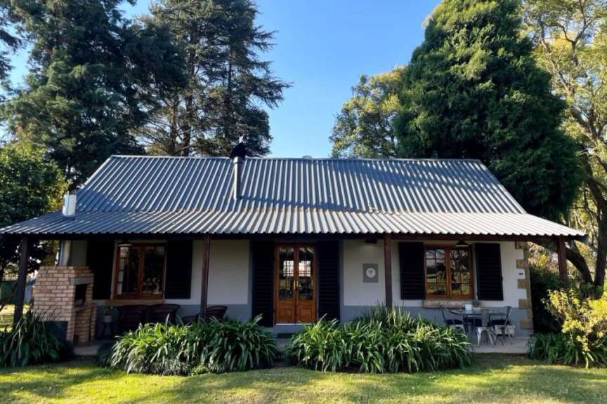 Ein kleines Haus mit einem Metalldach und einem Grill