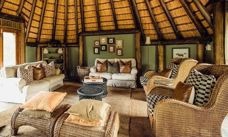 Ein Wohnzimmer mit Rattanmöbeln und einem Strohdach