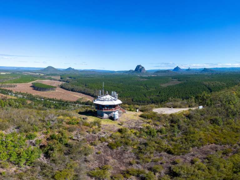 Ein Turm auf einem Hügel mit Blick auf einen Wald