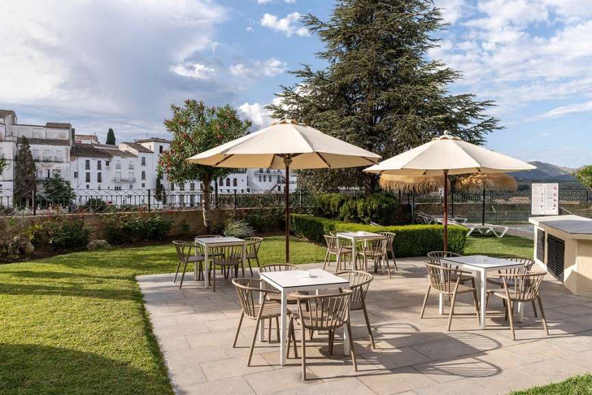 Eine Terrasse mit Tischen und Stühlen und Regenschirmen
