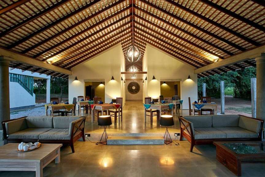 Ein eleganter Speisesaal mit Holzdach und gemütlichen Sofas lädt zum Verweilen ein.