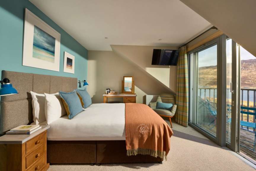Ein Schlafzimmer mit Blick auf das Meer und die Berge.