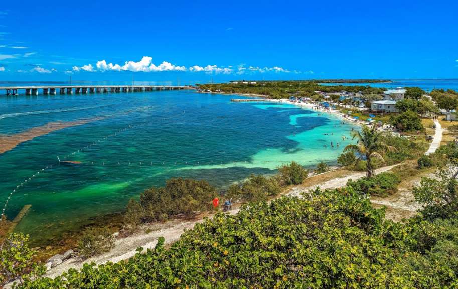 Ein Strand mit einer Brücke im Hintergrund