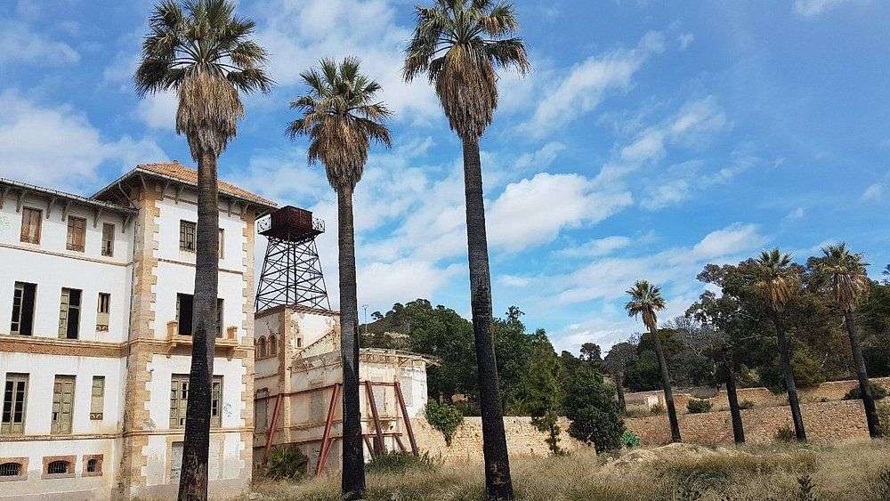 Ein Gebäude mit Palmen und einem Wasserturm davor