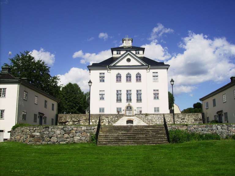 Ein großes weißes Gebäude mit einem Uhrturm darauf