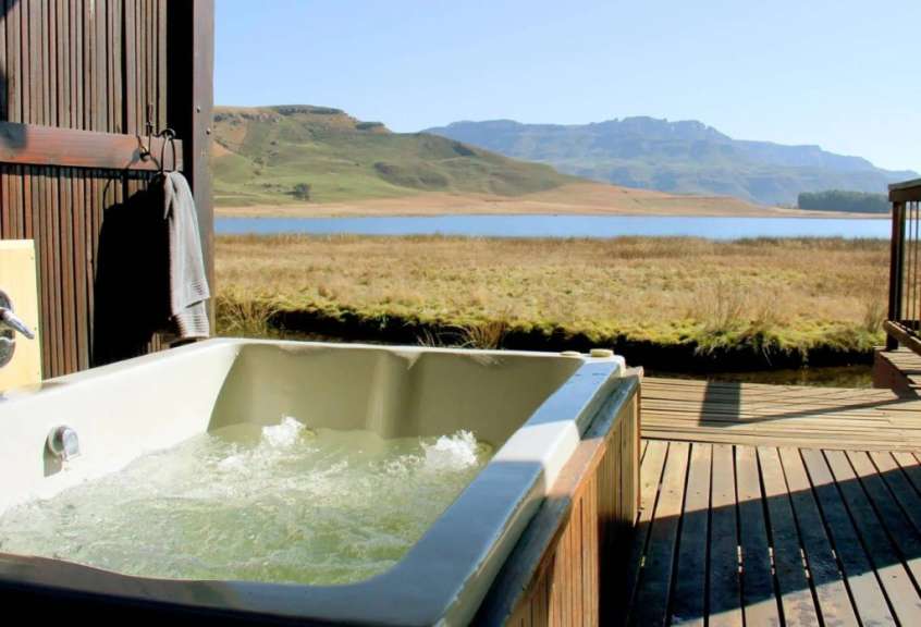 Eine Badewanne auf einem Holzdeck mit Blick auf einen See