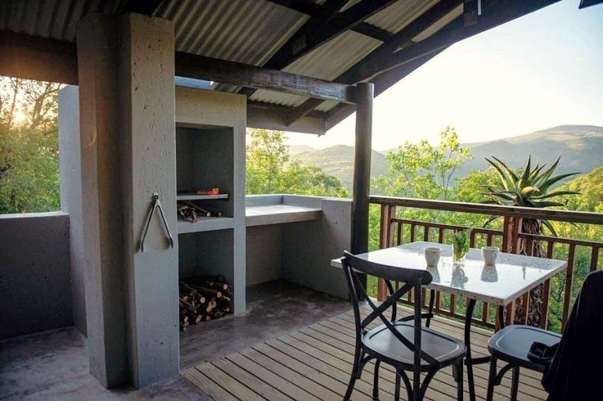Ein Tisch und Stühle auf einem Balkon mit Blick auf die Berge