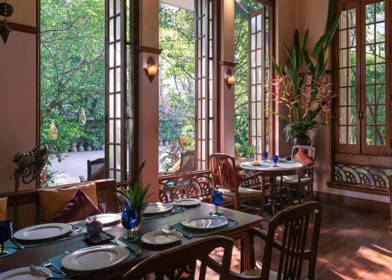 Ein Esszimmer mit Tischen und Stühlen und vielen Fenstern