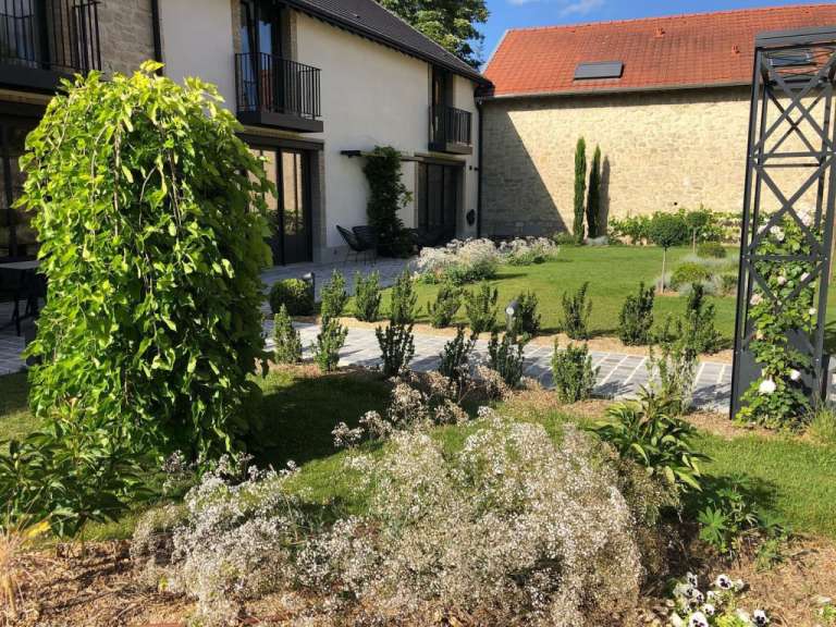 Ein Garten mit einem weißen Haus im Hintergrund