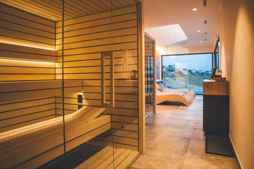 Ein Raum mit einer Sauna und Liegestühlen davor