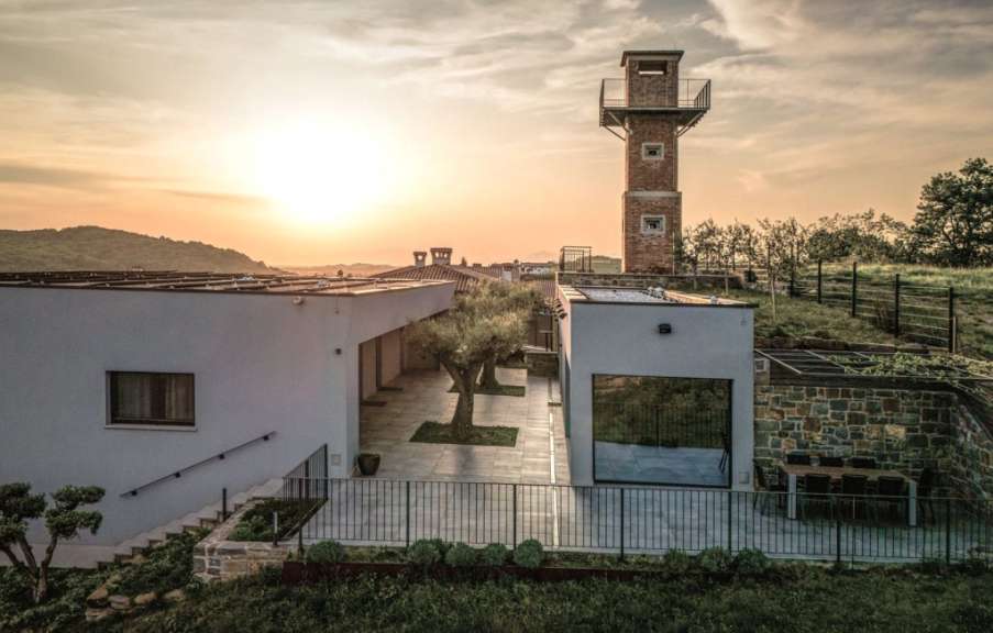 Ein weißes Haus mit einem Backsteinturm dahinter