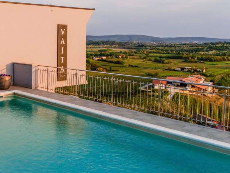 Ein swimmingpool neben einem gebäude mit dem schriftzug vajata
