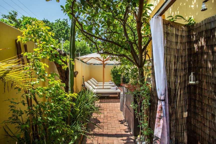 Eine Terrasse mit Liegestühlen und einem Sonnenschirm